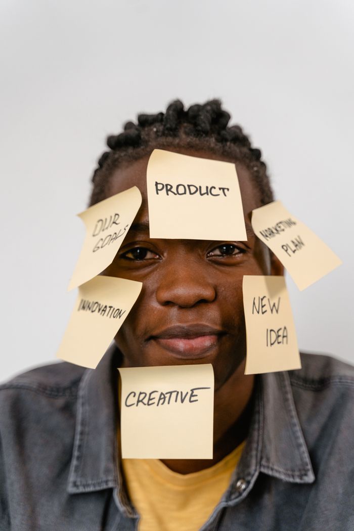 Creative representation of brainstorming ideas with sticky notes on mans face for innovation and planning.